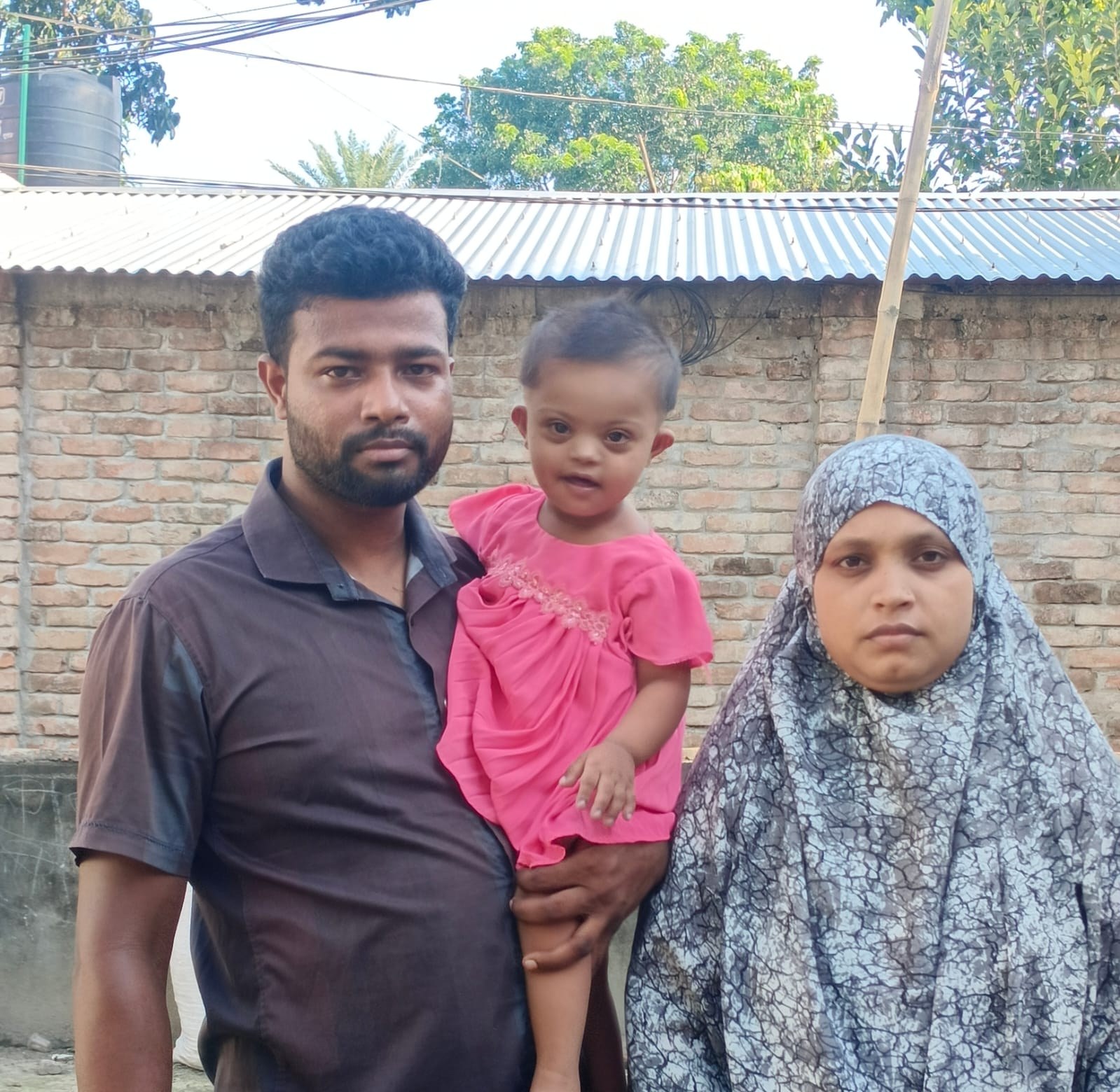 Rafiya Sheikh held by her father Md Rubel Sheikh, beside her mother Rokeya Khatun